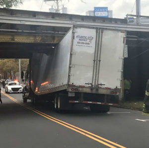 Truck stuck under bridge